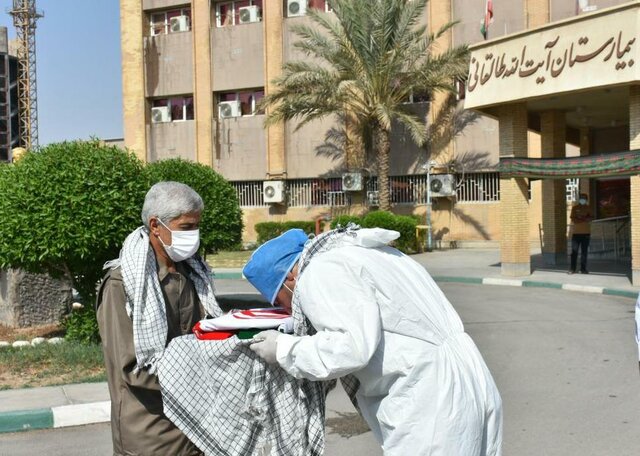 اهدای پرچم ایران از سوی جانباز دفاع مقدس به مدافع سلامت آبادان